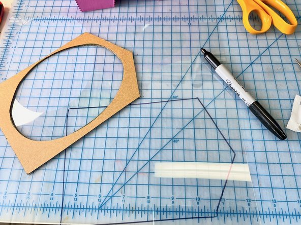 We traced the piece of cardboard that we cut out of the back of the pig onto a piece of craft plastic to act as the window in the front of the pig. We placed it inside and used a dab of hot glue to keep it in place.