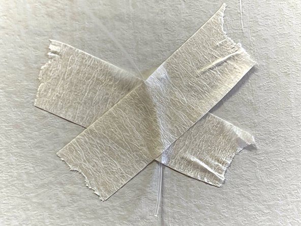 Tape the other end of the fishing line to the wall on the other side of the room. There should be about 3 inches of slack left in the line to allow the motor to move.