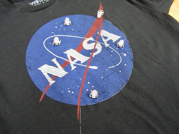 We sewed one solid line of Conductive Thread around the NASA logo, with it ending on the furthest out LED.