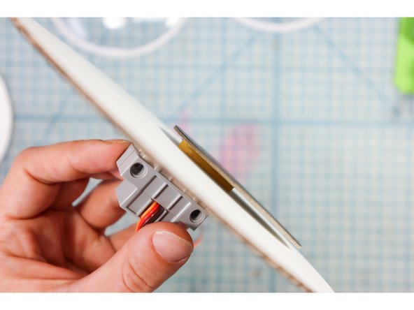 Place the motor through the hole from the back and attach the pupil on top as shown.
