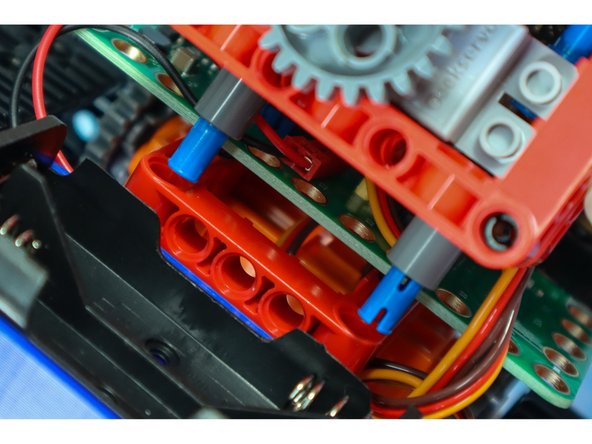 Connect the gear assembly to the red fame on the body as shown.