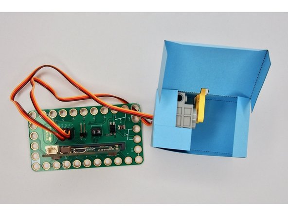 Now that you know which direction the axles on the servo are oriented, you can attach the LEGO axle mounts. (Just slide them through the slot on the top).