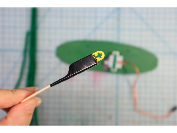 Use electrical tape to attach it to the LEGO, making sure not to cover the &quot;+&quot; at the end, as shown.