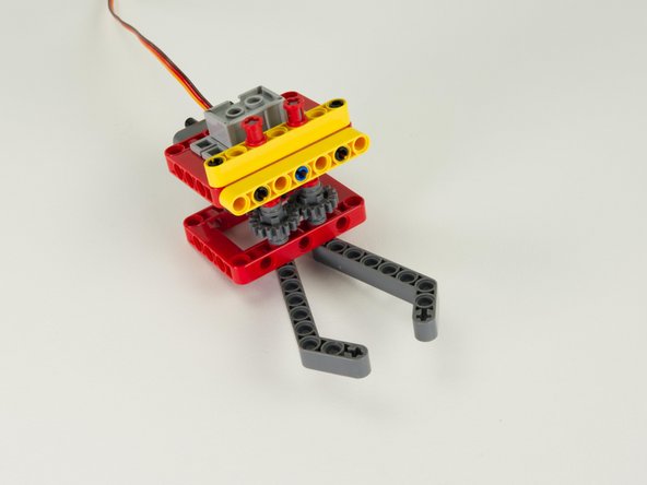 Add two red bushings to the top of the axles that are sticking out of the top of the assembly. These should hold the axles in place so they cannot fall out.