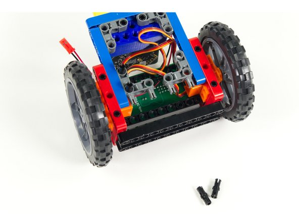 Add four short pins to the 90 degree connectors as shown, two for each connector, in line with the blue beams.