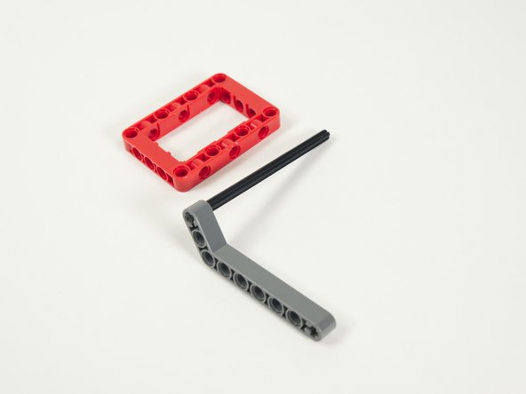 Slide the axle (with the beam attached) into the red frame.