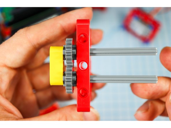 Push the pieces down until they stop, interlocking the gears.