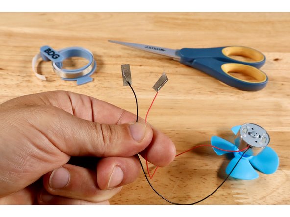 Push the blue fan onto the motor axle. Afterward, use a wire strippers to strip 1/4&quot;-1/2&quot; of the insulation from the ends of each motor wire.