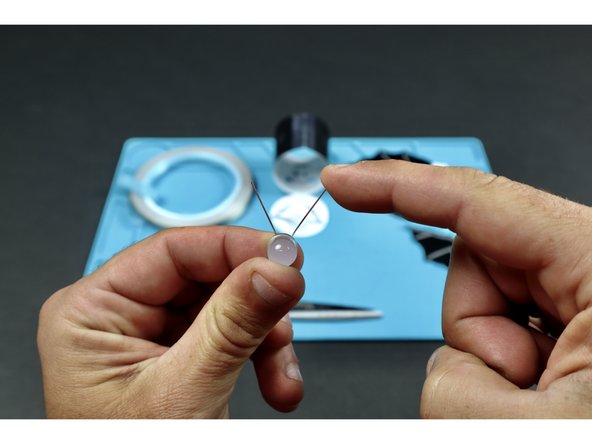 Take care to flatten the legs so that the long and short leg are oriented in the way shown on the back of the circular lid.