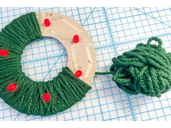 My first idea was to use green yarn. I made a ball of yarn that could fit inside the center opening and wound until the entire circle was covered.