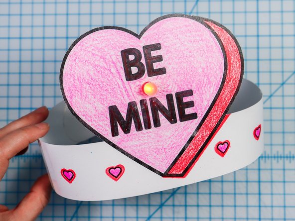 Cut out the side strips and tape them to the hat with the slits facing up on one side and down on the other.