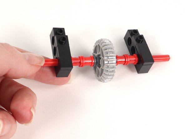 The axle should be through the first hole (under the 1x2 tile).