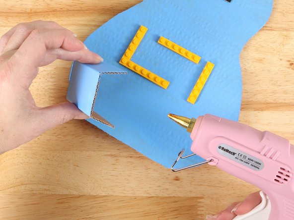 Glue the battery compartment into place below the LEGO plates. Make sure it is not too close to the LEGO plates.