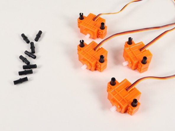 Add 4 black pins to a continuous rotation servo. You will need to do this to all 4 servos.