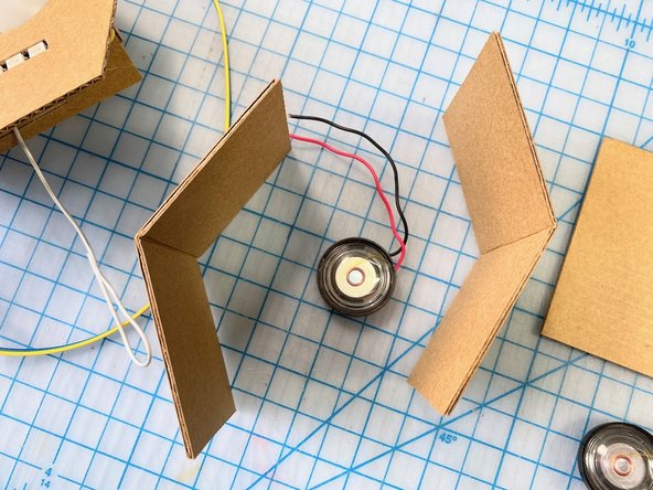 We cut two pieces of cardboard to be the sides of the head, allowing them to fold instead of cutting separate pieces. We thought this made the design look cleaner.