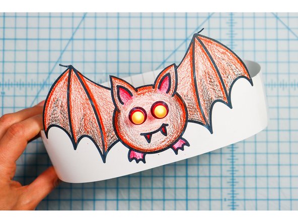 Cut out the side strips and tape them to the hat with the slits facing up on one side and down on the other. 