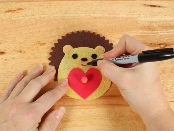 Use a black permanent marker to draw a mouth on the Hedgehog.