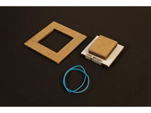 Place Piece 7 on top of the assembly created in the previous steps. The stack of three piece (8, 9, and 10) should stick up through the hole. Hold the pieces together with two thin rubber bands.