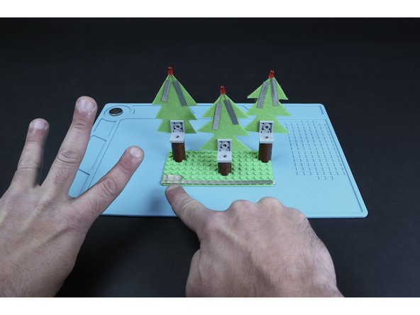 Now, create a single path on the last row of LEGO posts behind the trees from edge to edge. Then overlap (3) 3-post long segments atop the leftmost side of that first path. This will be where your battery connects to the circuit.