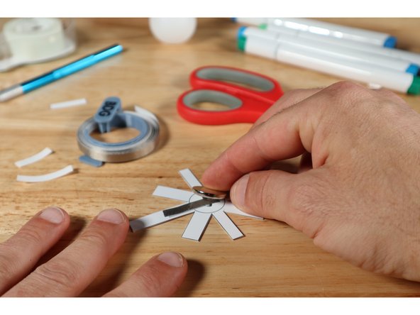 Stick your battery atop the Maker Tape loop as shown. The Positive (+) Side of the battery should face UP.