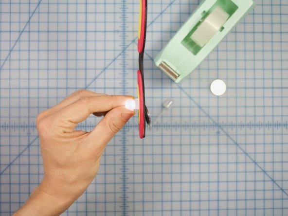 When the tape is secure, hold the LED in one hand and use the other hand to bend the battery flat against the back, with the positive side facing up and the negative side facing the foam.