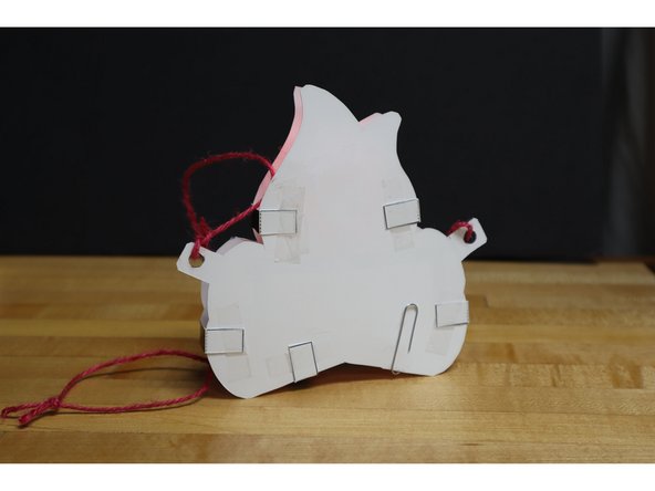 Attach the tab legs to the back/bottom of the campfire with tape or glue.