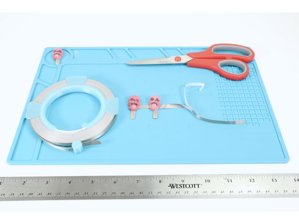 Repeat the previous step until all 3-4 of your molded LEDs have their short, negative legs connected by this horizontal piece and the whole arrangement is stuck to the table.
