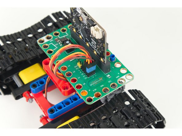 Plug the left servo connector into the row for Pin 13. The orange wire should go to the pin closest to the 13 on the board, the red wire goes into the +5v row, and the brown wire goes into the - row, which is ground.