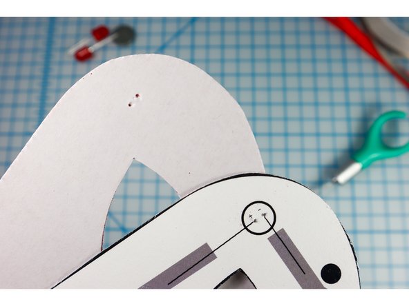 Use an awl, push pin, safety pin, or other pointy tool to make holes for the LED legs to stick through.