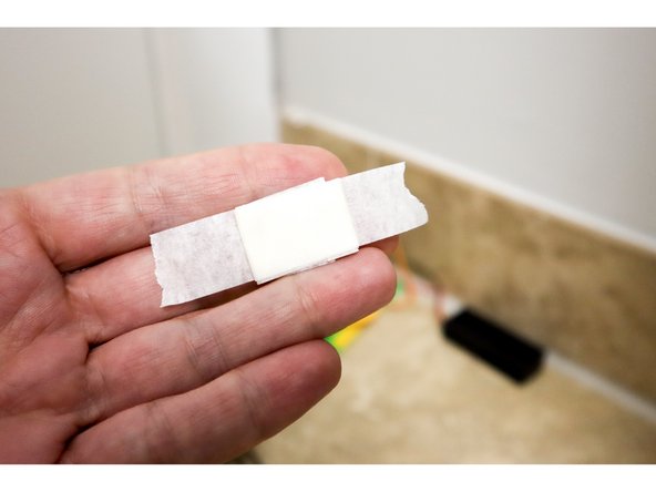 With the project in place behind a door, adhere the two runs of tape to the door frame leaving about 1 inch between them.