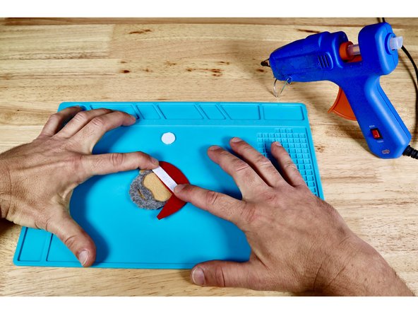 Press the long fur detail piece into place atop the hot glue.