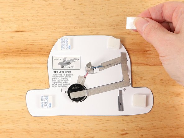 Add four small pieces of double-sided foam tape to the squares around the outline of the monster.