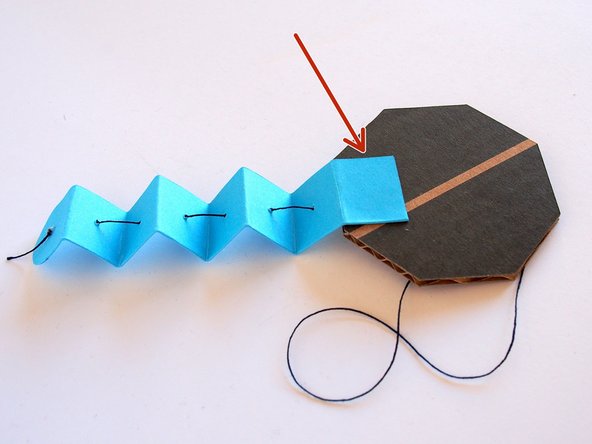 Glue a tentacle to the bottom of the cardboard base