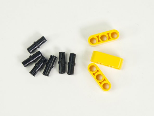 Add two black pins to each yellow beam, on the ends, leaving the middle holes empty.