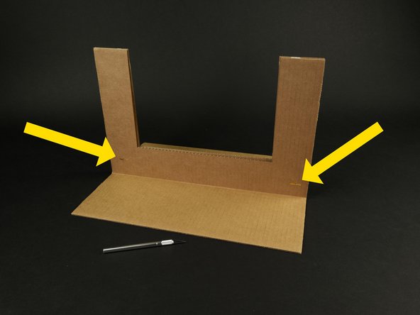 Poke holes through the three layers of cardboard as shown, and insert two of the brass fasteners to hold them all together.