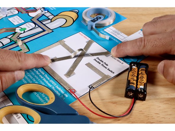 Measure, cut, peel, and stick the Maker Tape segments of the upper part of the criss-cross. This involves a jumped wire just like you saw in the Green and White LED/ROV Outcome paths. Use extra length to enable this path to cross over and above the lower part without touching it.
