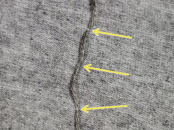 Run the thread to the negative side of the LED by picking up just one thread of the t-shirt material every half-inch. This will tack the thread in place and won't be visible from the front of the shirt.