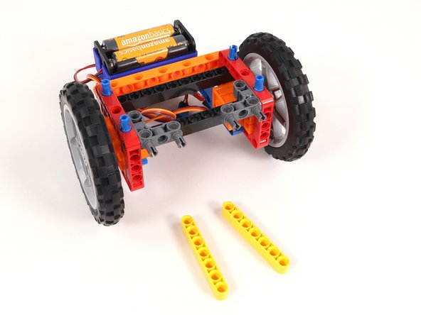 Add a yellow beam onto the blue pins on each side of the Rover