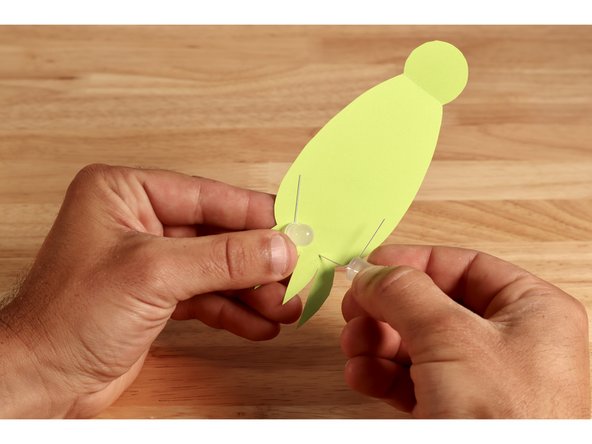 Poke the long LED legs through the template just above the arms of the cephalopod. Bend THOSE legs flat against the opposite side of the shape toward the tab.