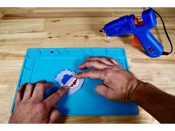 Locate the upper and lower teeth pieces and position them atop the matching potions of your hot glue bead.