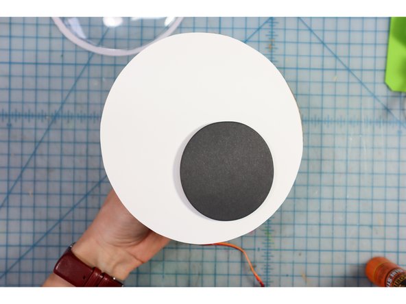 Place the motor through the hole from the back and attach the pupil on top as shown.