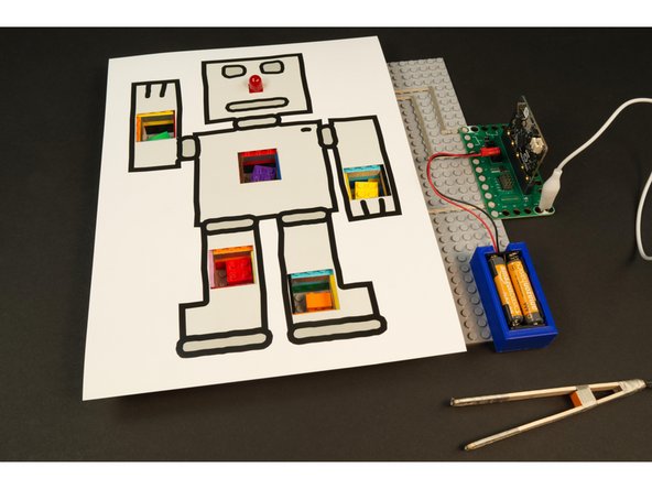 We added a few bricks two levels high around the perimeter of the baseplate so our paper robot could rest on top of them.