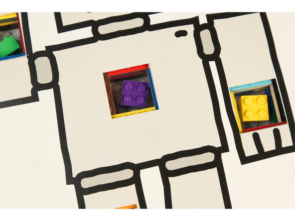 We also added a few pieces of tape to hold our robot in place. If the template covers the edges of the pockets your tweezers may not make contact with the Maker Tape.