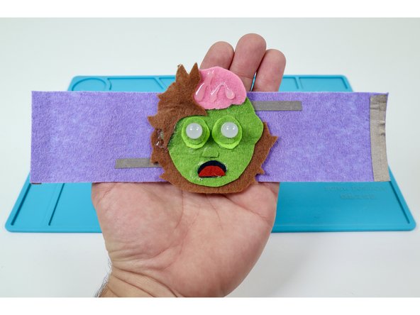 Now lift up the edge of the felt design that hides the LONGER LED legs enough to reveal them.