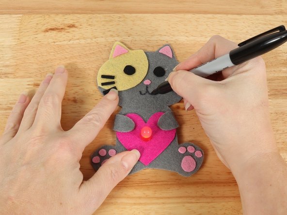 Use a black permanent marker to draw a mouth on the Cat.