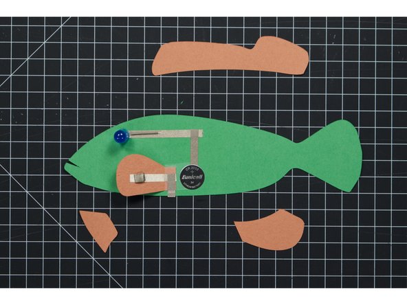 Once you’ve got the tape loops in place you can add the battery and then stick the fin down to the top. If you’ve done everything correct the eye should light up!