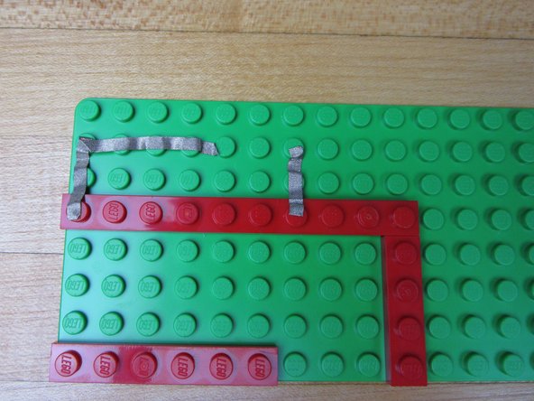 Run Maker Tape from the left side Ground Pin (white circle) to the Piezo Speaker.