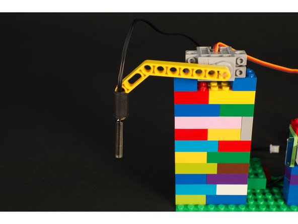We're using a LEGO Technic Beam 3 x 3.8 x 7 Beam Bent 45 Double (32009 / 41486) which mounts to the servo shaft and is long enough to dip into our drink.