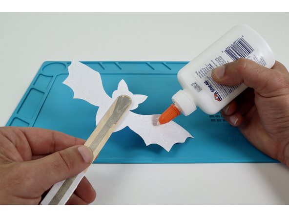 Use some glue to stick the back panel in place as shown to cover the circuitry.