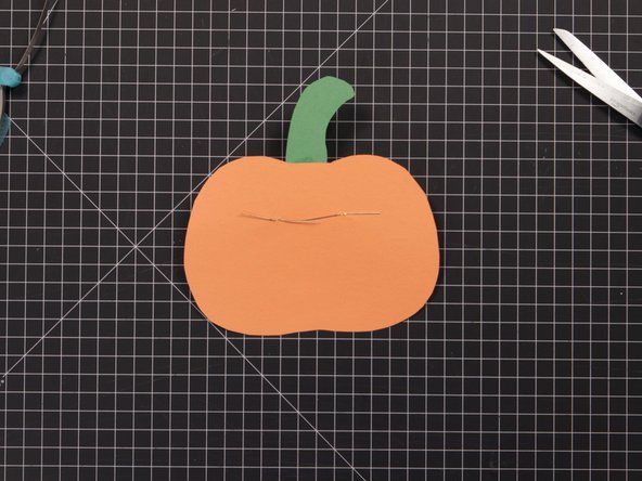 Turn your Jack-O-Lantern over and bend the LED legs flat against the paper.